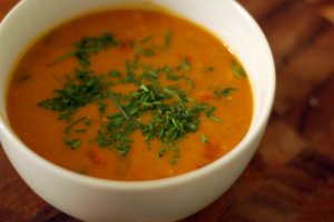 Recept online: Dýňová polévka: Bohatě kořeněná polévka z dýně, pórku a červené čočky se smetanou a proužky osmažené slaniny